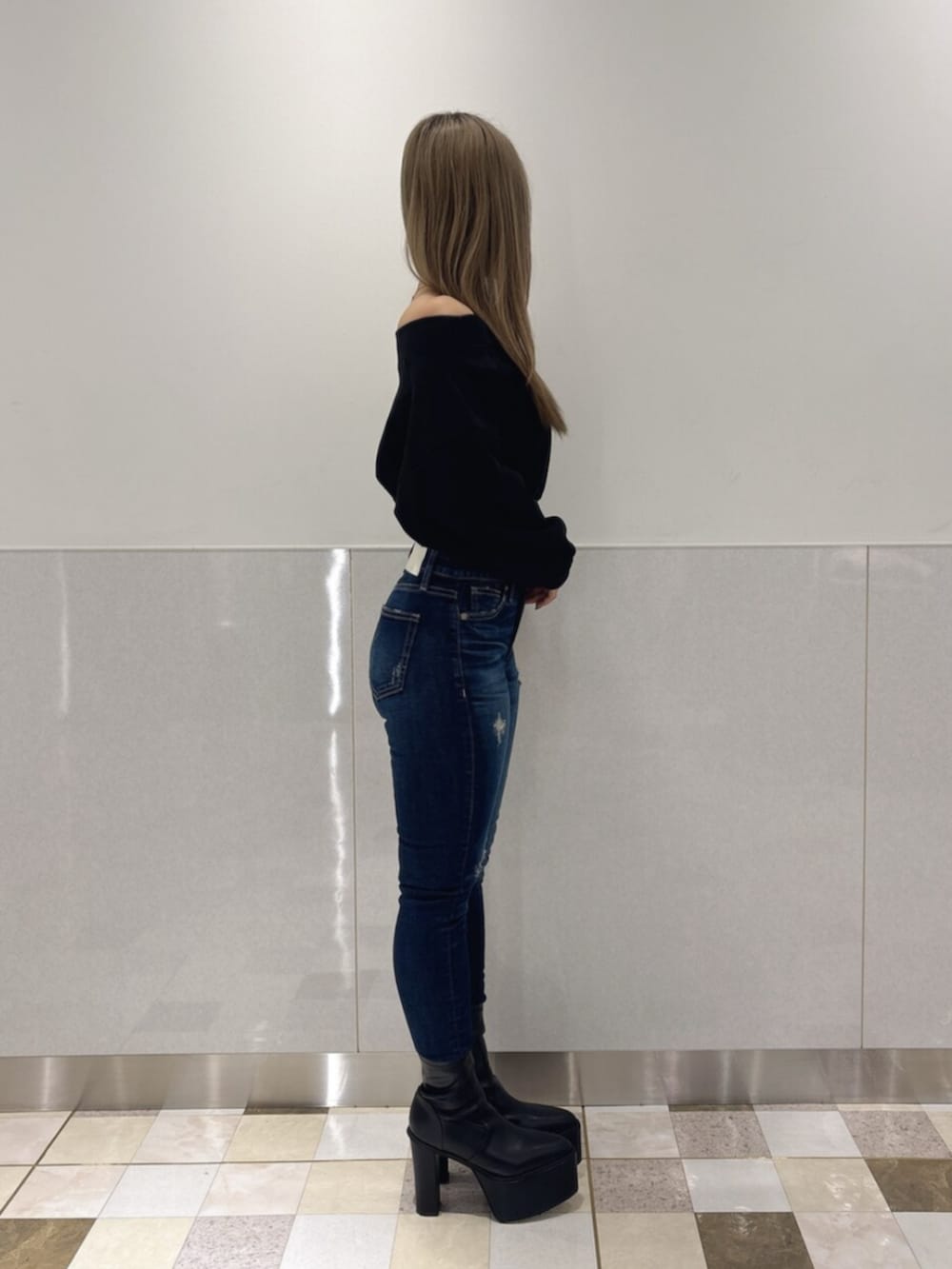 ブルー系のデニムパンツ、ブラック系のブーツ、ブラック系のTシャツ/カットソーを着用したレディースの秋コーディネートの2枚目の写真