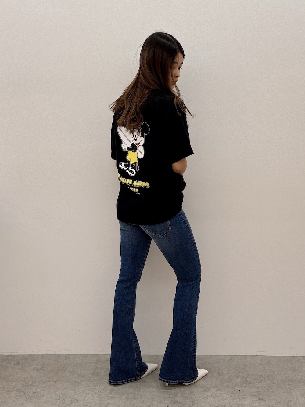 ブラック系のTシャツ/カットソー、ブルー系のデニムパンツ、ホワイト系のパンプスを着用したレディースの春コーディネートの2枚目の写真