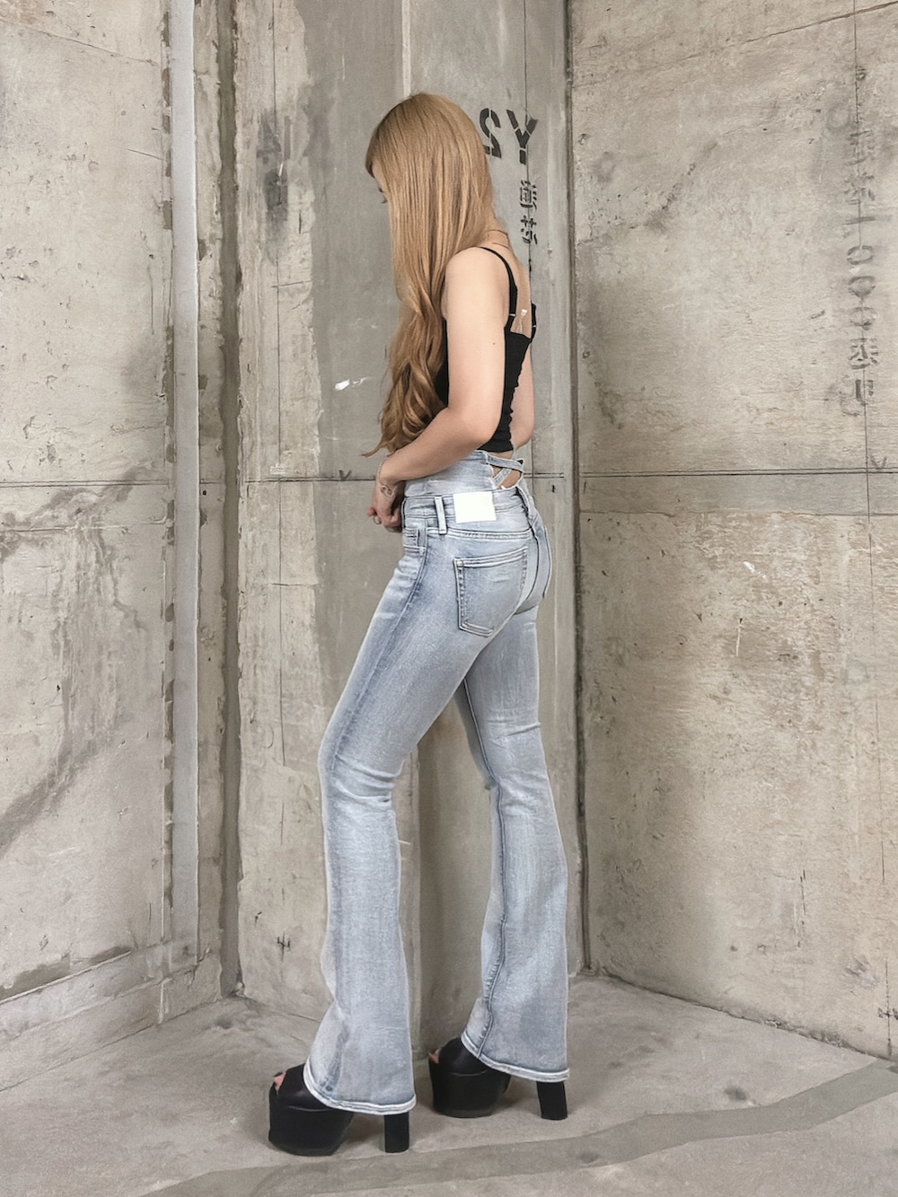 ブラック系のキャミソール、ブルー系のデニムパンツ、ブラック系のサンダルを着用したレディースの夏コーディネートの2枚目の写真