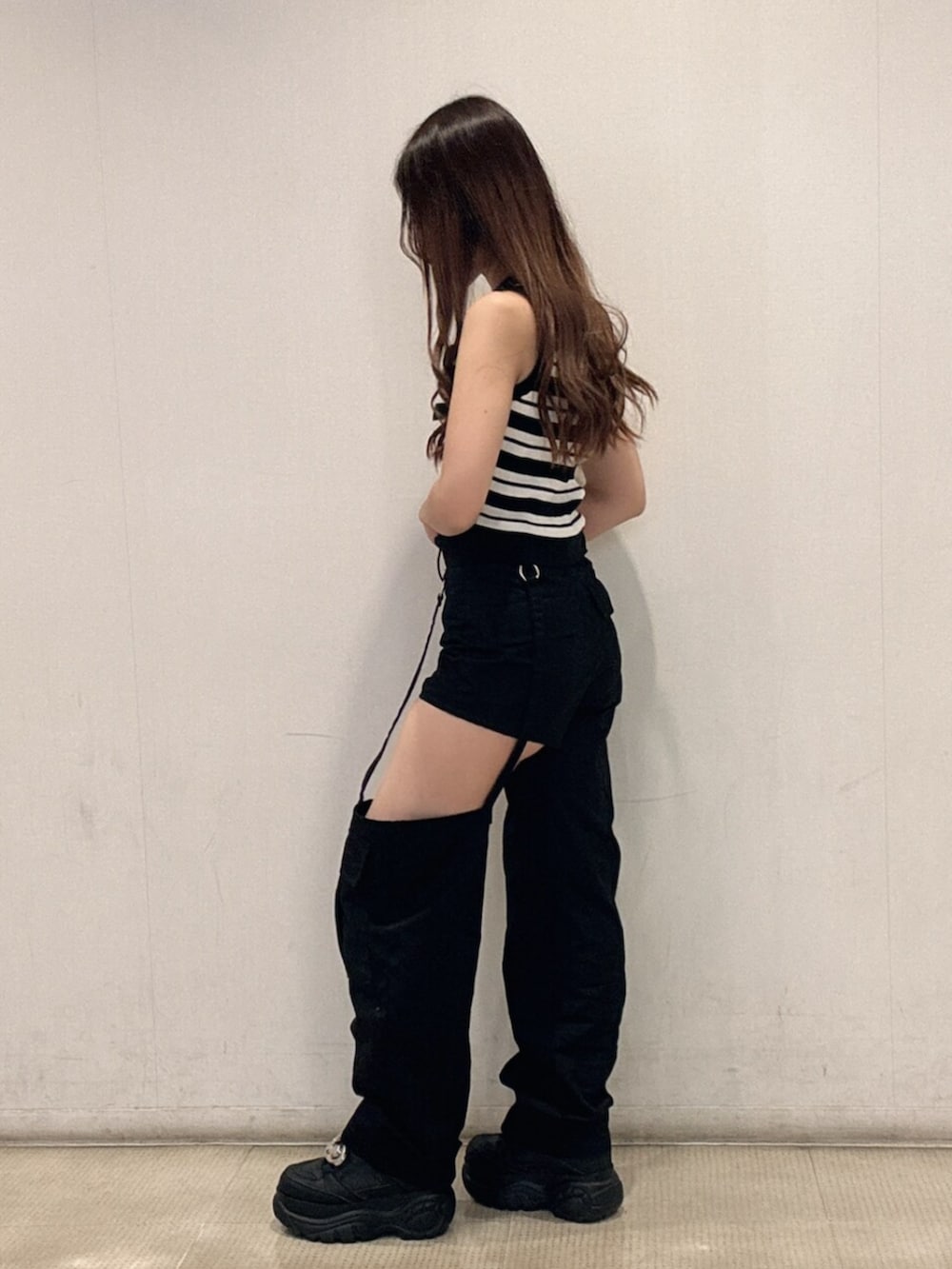 ブラック系のスニーカー、ホワイト系のニット/セーター、ブラック系のその他パンツを着用したレディースの春コーディネートの2枚目の写真