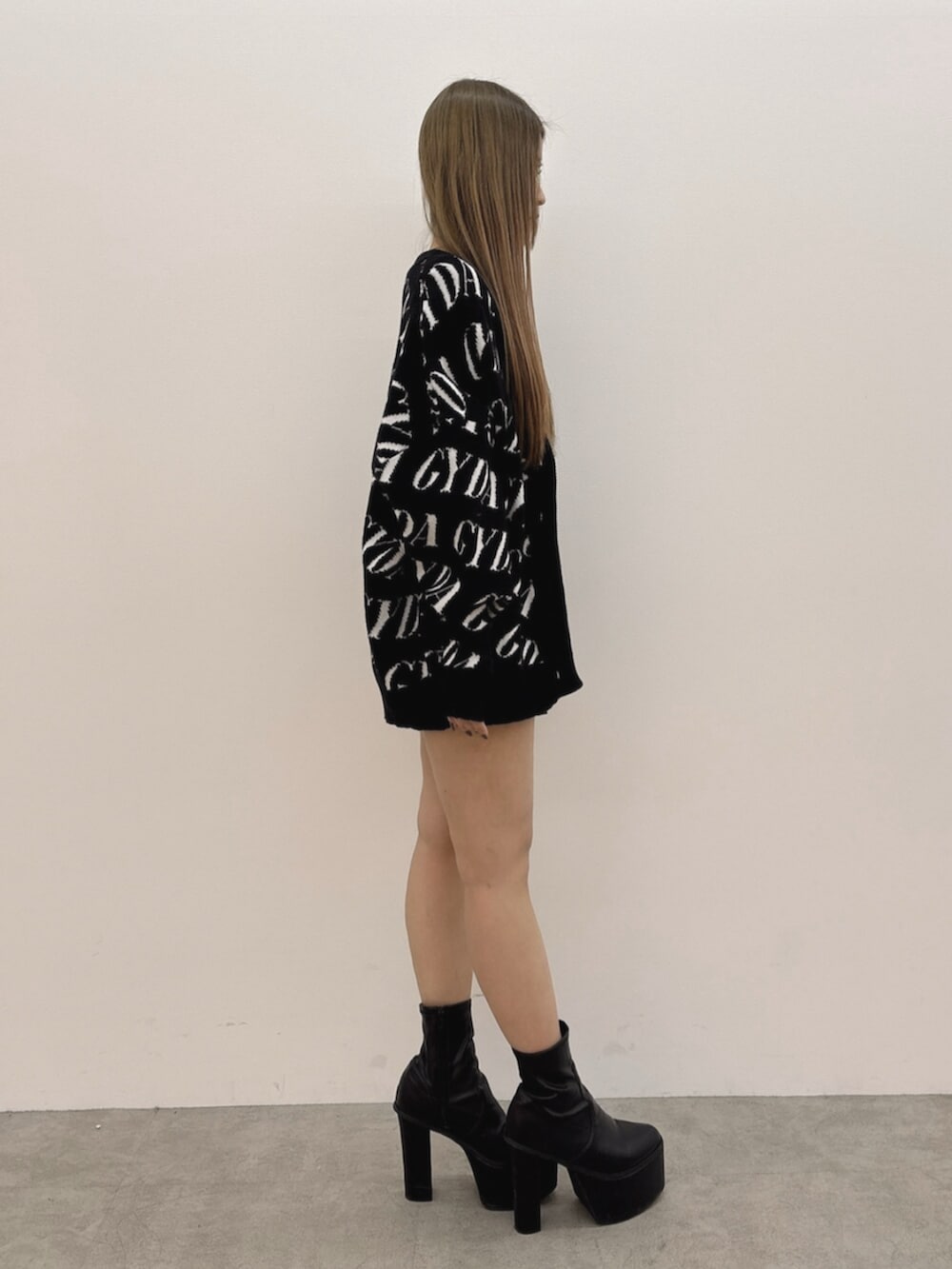 ブラック系のブーツ、ブラック系のTシャツ/カットソー、グレー系のスカートを着用したレディースの冬コーディネートの3枚目の写真