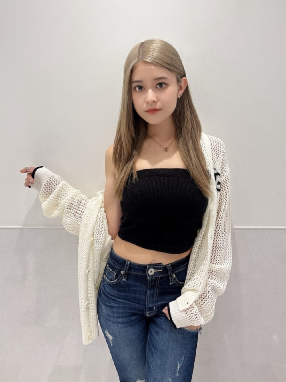 ブルー系のデニムパンツ、ブラック系のキャミソール、ブラック系のブーツを着用したレディースの夏コーディネートの4枚目の写真