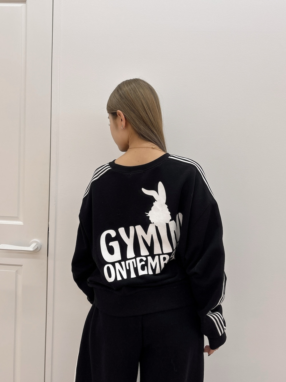 ブラック系のスウェットパンツ、ブラック系のスウェット、ブラック系のブーツを着用したレディースの冬コーディネートの5枚目の写真