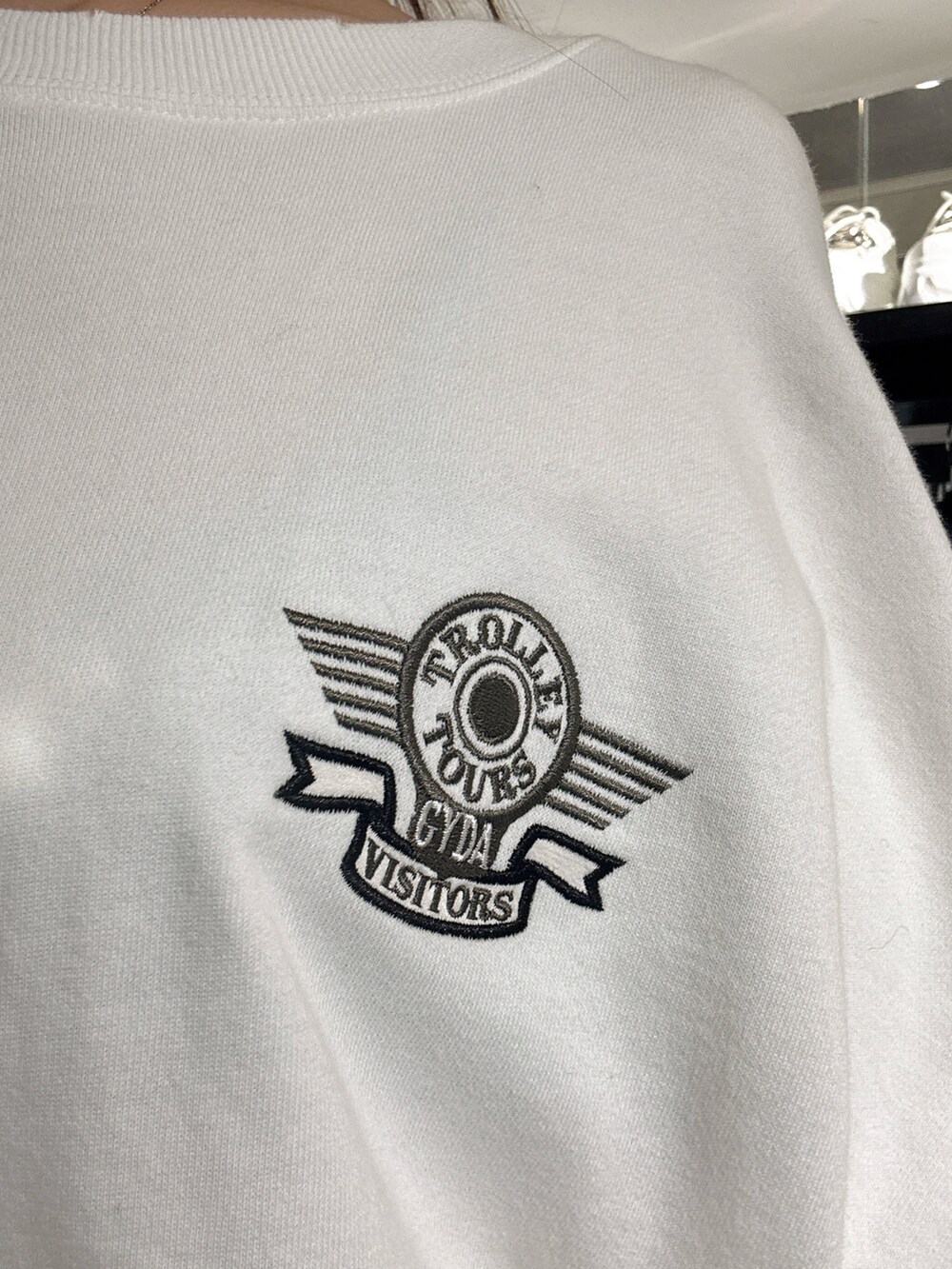 ホワイト系のスウェット、ブルー系のデニムパンツ、ブラック系のブーツを着用したレディースの秋コーディネートの6枚目の写真