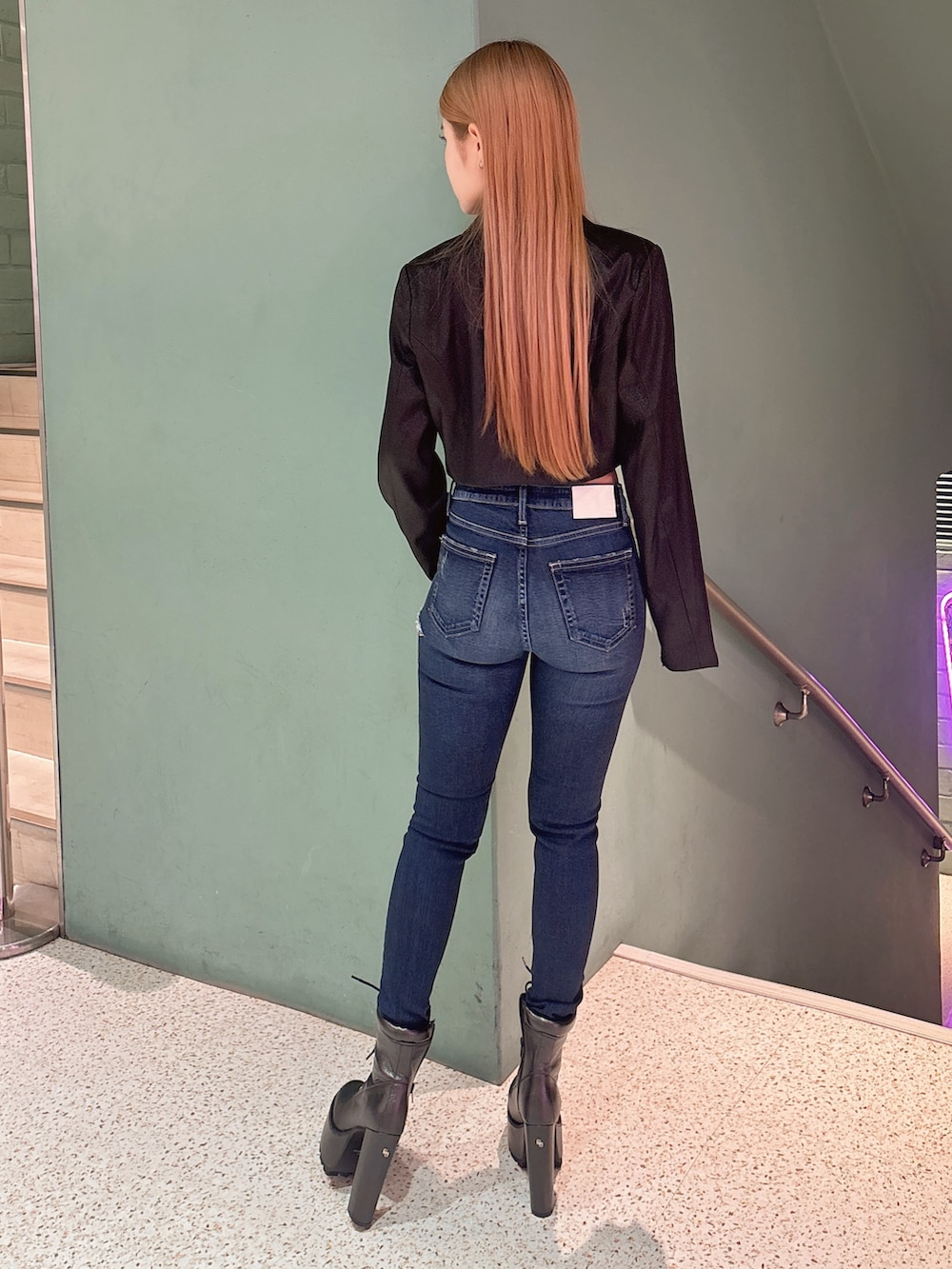 ホワイト系のキャミソール、ブラック系のテーラードジャケット、ブルー系のデニムパンツを着用したレディースの春コーディネートの3枚目の写真