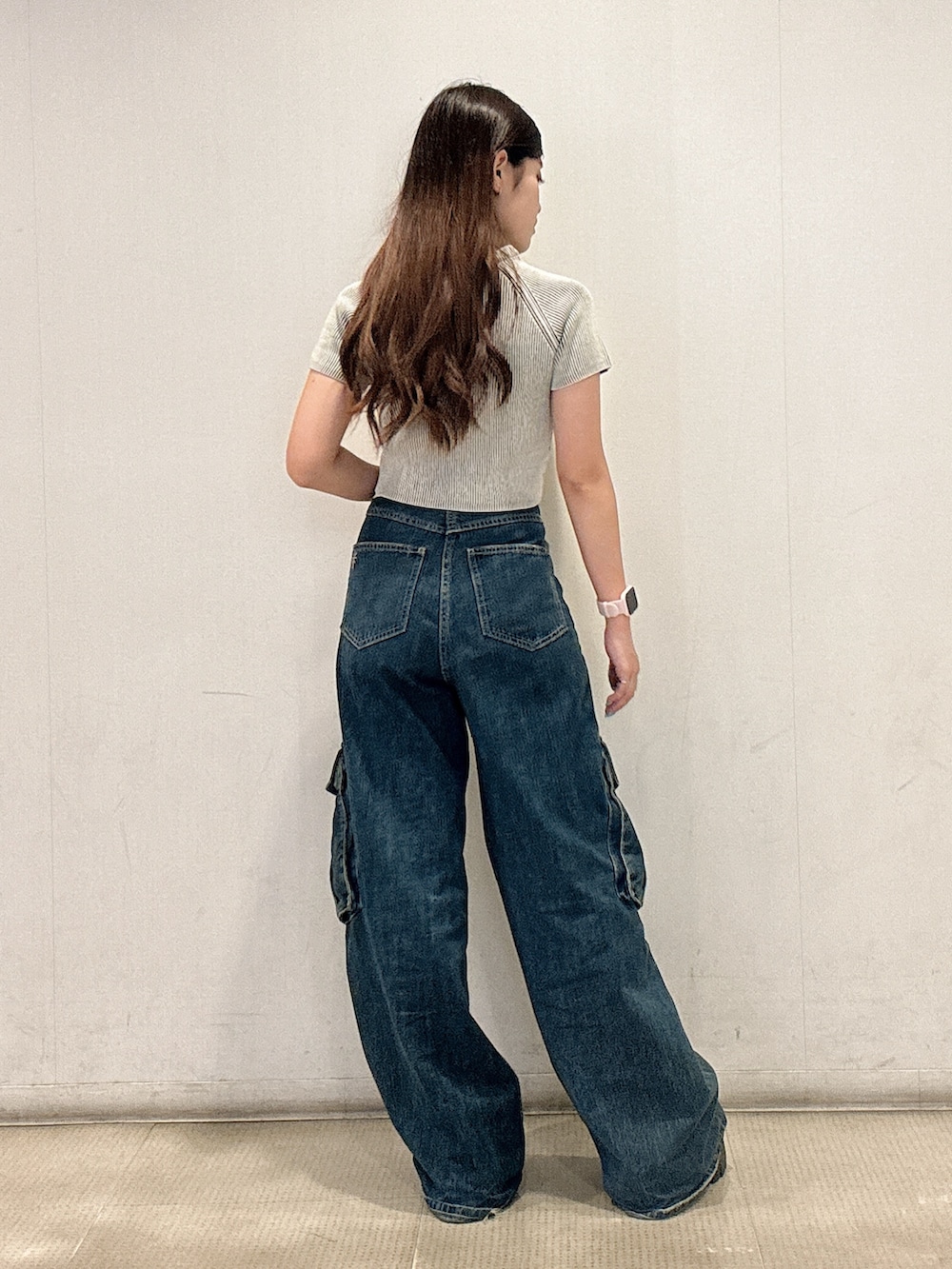 ホワイト系のニット/セーター、ブルー系のつなぎ/オールインワン、ブラック系のスニーカーを着用したレディースの夏コーディネートの3枚目の写真