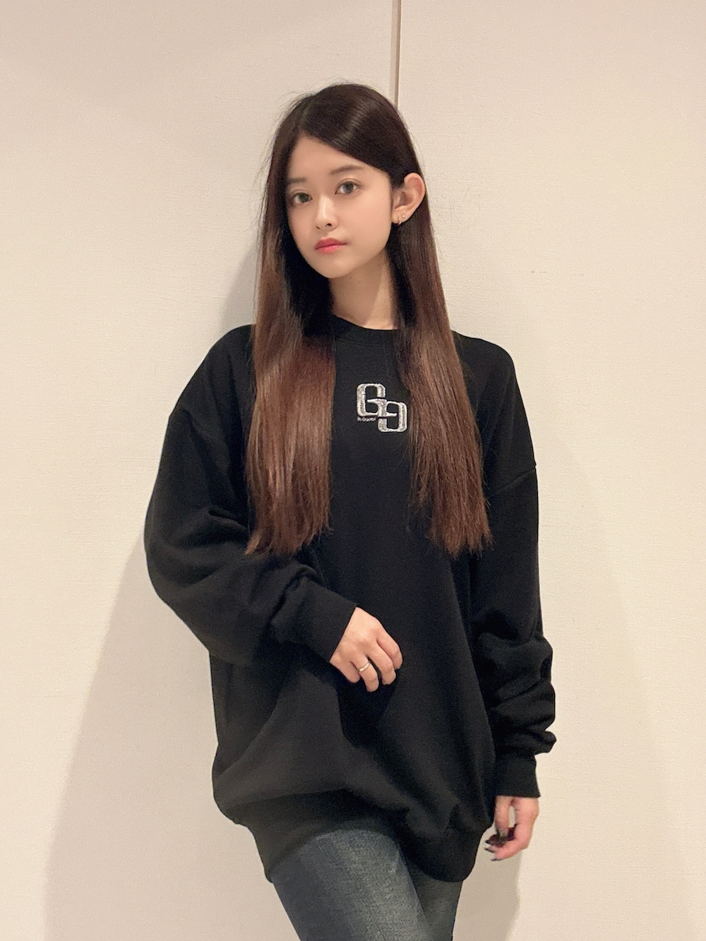 ブラック系のパーカー、ブルー系のデニムパンツ、ブラック系のブーツを着用したレディースの秋コーディネートの4枚目の写真