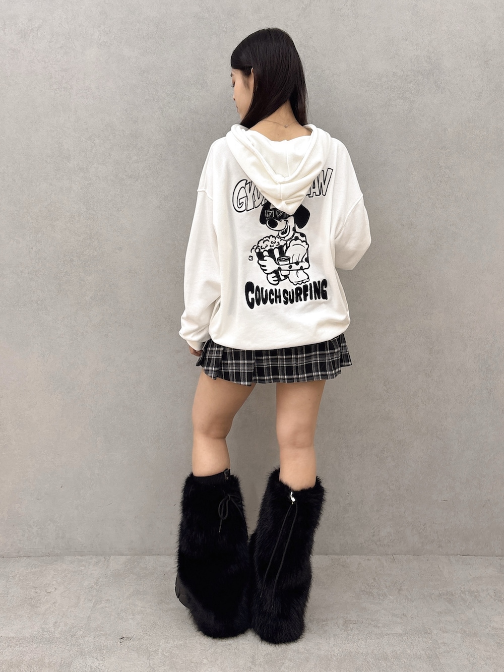 ホワイト系のパーカー、ブラック系のスカート、ブラック系のブーツを着用したレディースの秋コーディネートの3枚目の写真