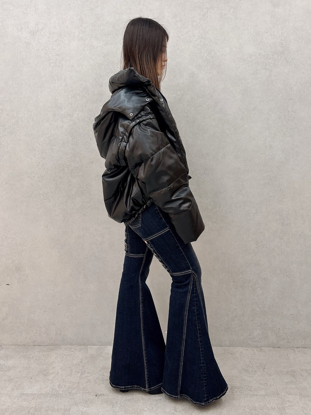 ホワイト系のニット/セーター、ブラック系のダウンジャケット/コート、ブラック系のブーツを着用したレディースの秋コーディネートの2枚目の写真