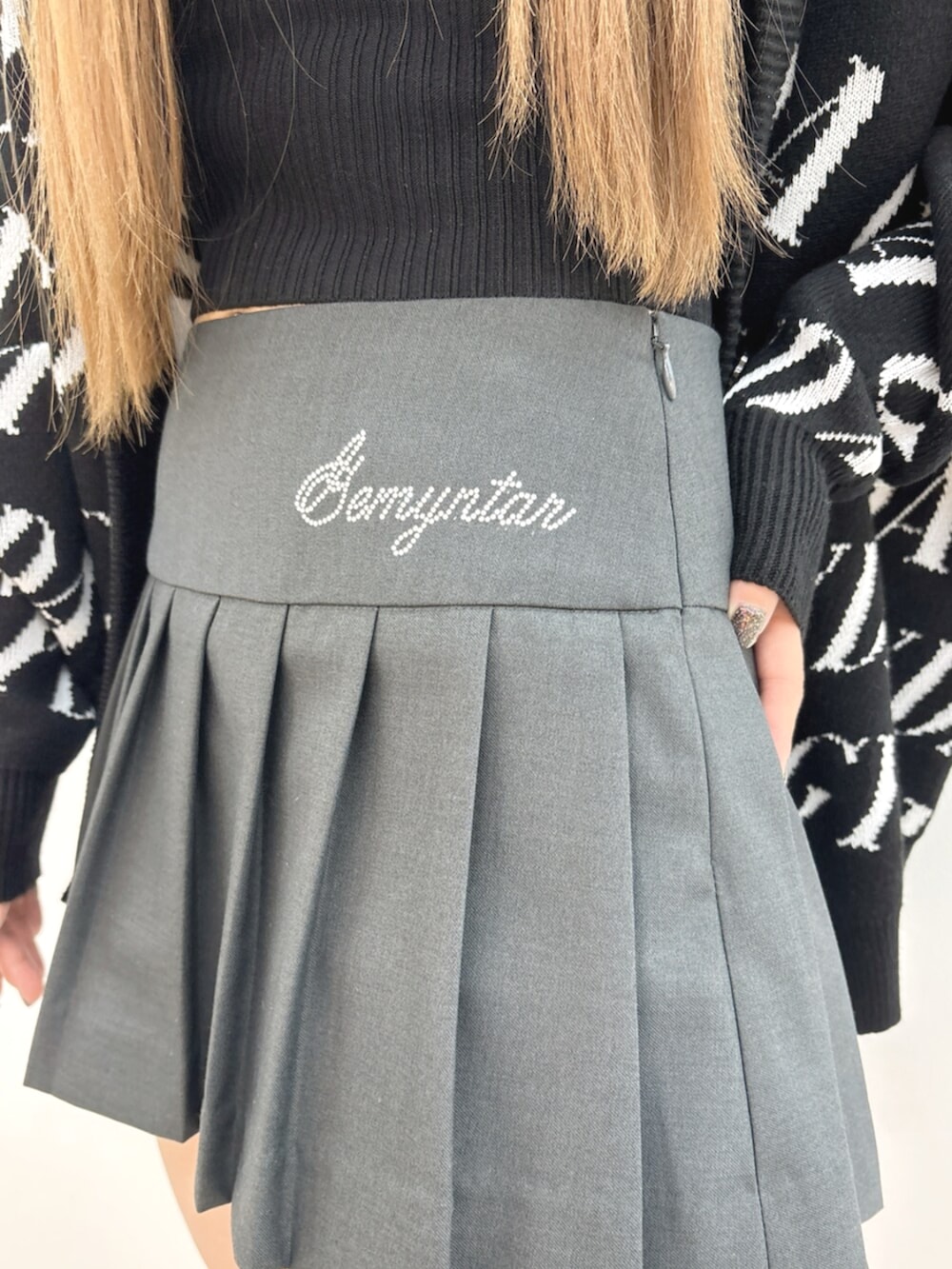 ブラック系のブーツ、ブラック系のTシャツ/カットソー、グレー系のスカートを着用したレディースの冬コーディネートの9枚目の写真