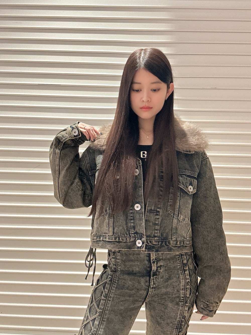 ブラック系のニット/セーター、ブルー系のデニムパンツ、ブルー系のデニムジャケットを着用したレディースの秋コーディネートの5枚目の写真