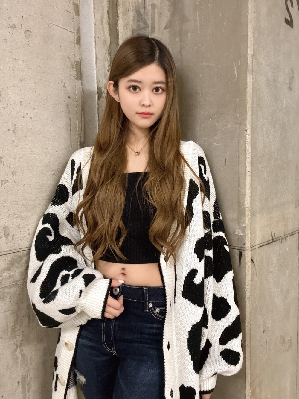 ブラック系のキャミソール、ホワイト系のカーディガン/ボレロ、ブルー系のデニムパンツを着用したレディースの春コーディネートの4枚目の写真