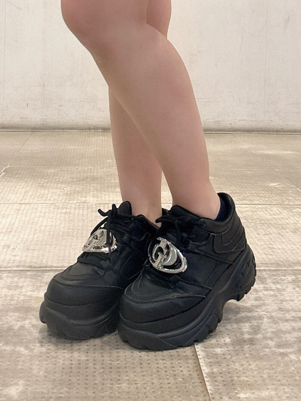 ブラック系のスニーカー、ホワイト系のタンクトップ、ブルー系のデニムパンツを着用したレディースの春コーディネートの7枚目の写真