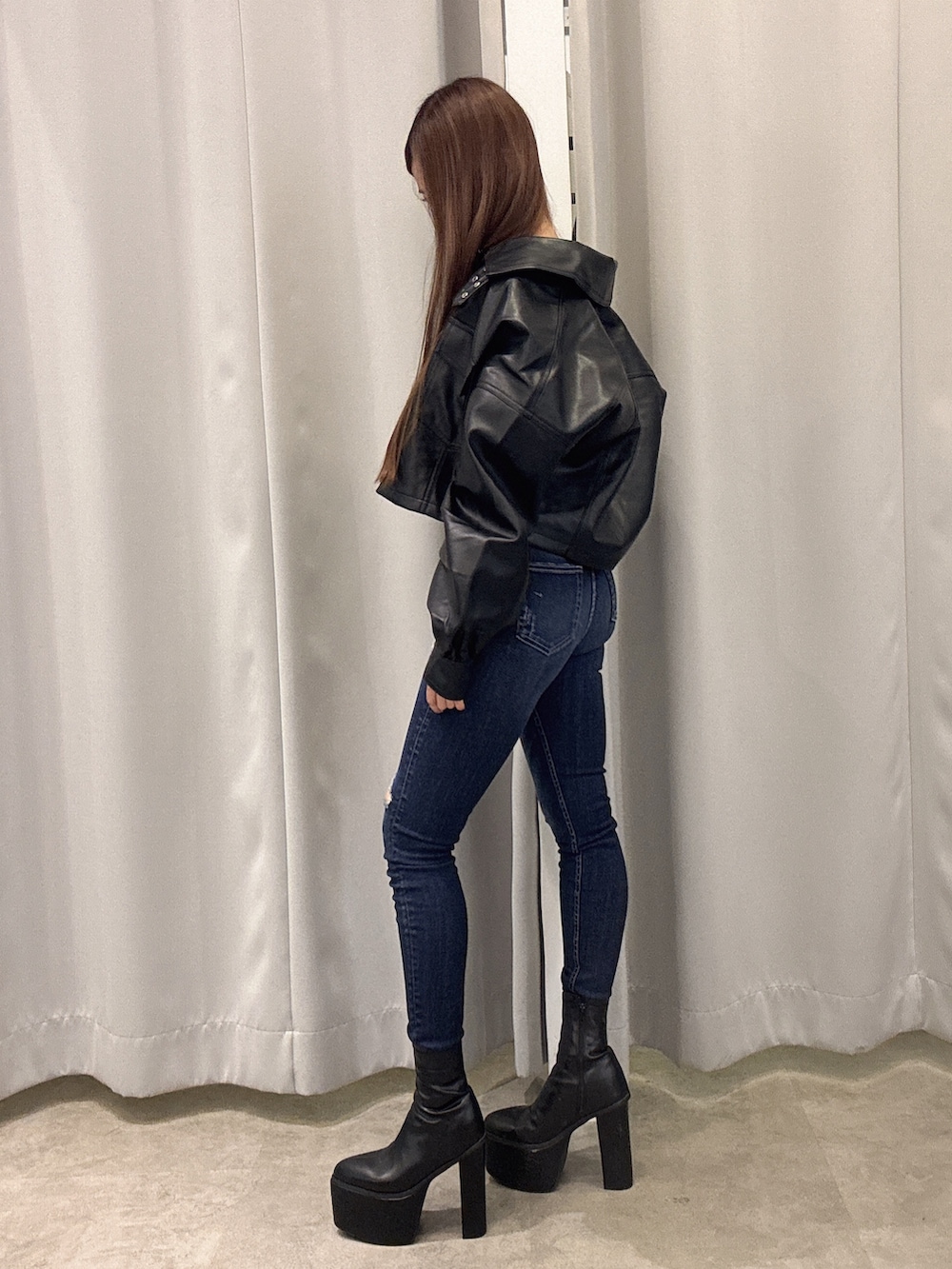 ブラック系のライダースジャケット、ブラック系のTシャツ/カットソー、ブルー系のデニムパンツを着用したレディースの秋コーディネートの2枚目の写真