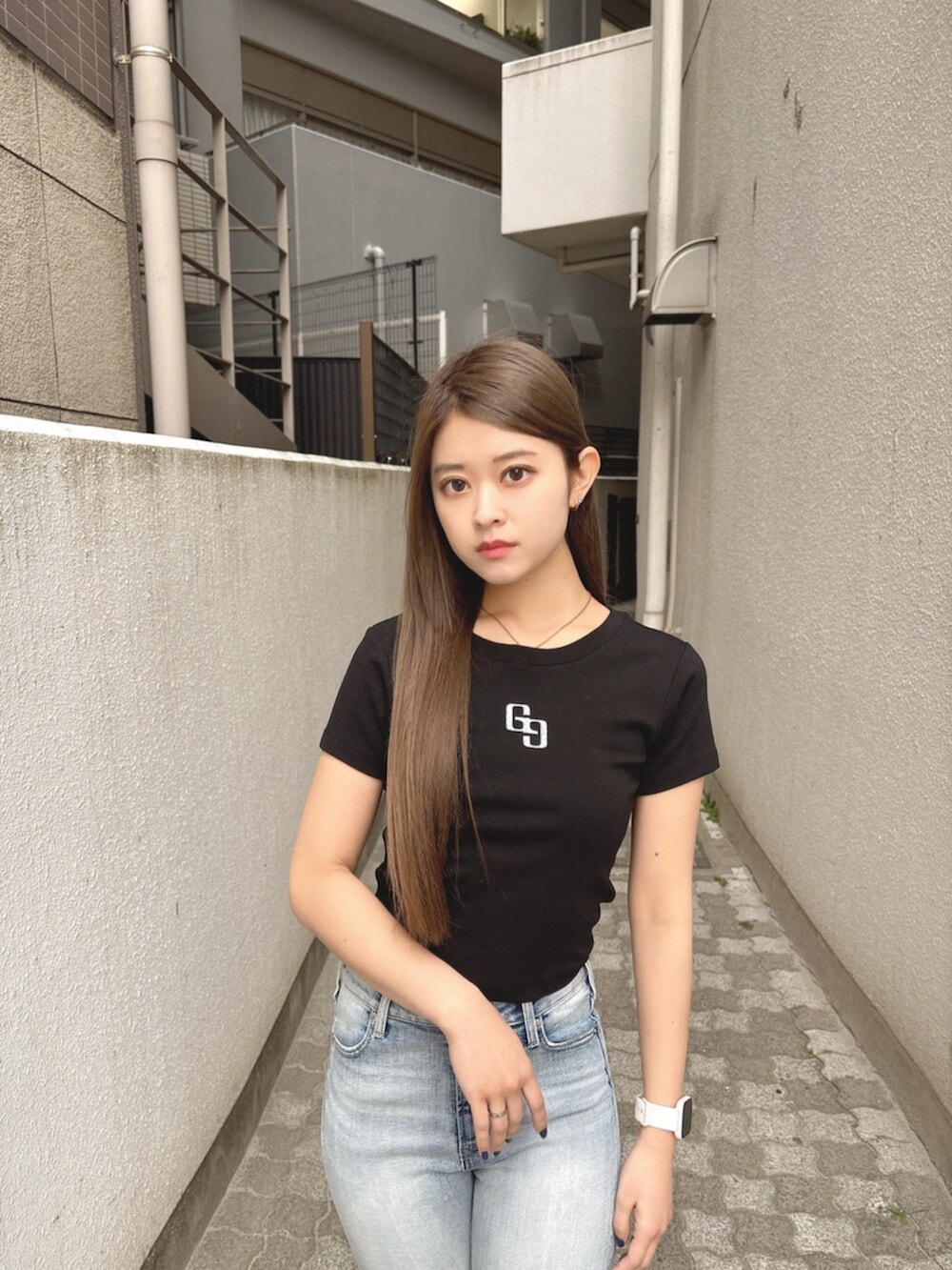 ブラック系のサンダル、ブラック系のTシャツ/カットソー、ブルー系のデニムパンツを着用したレディースの春コーディネートの4枚目の写真