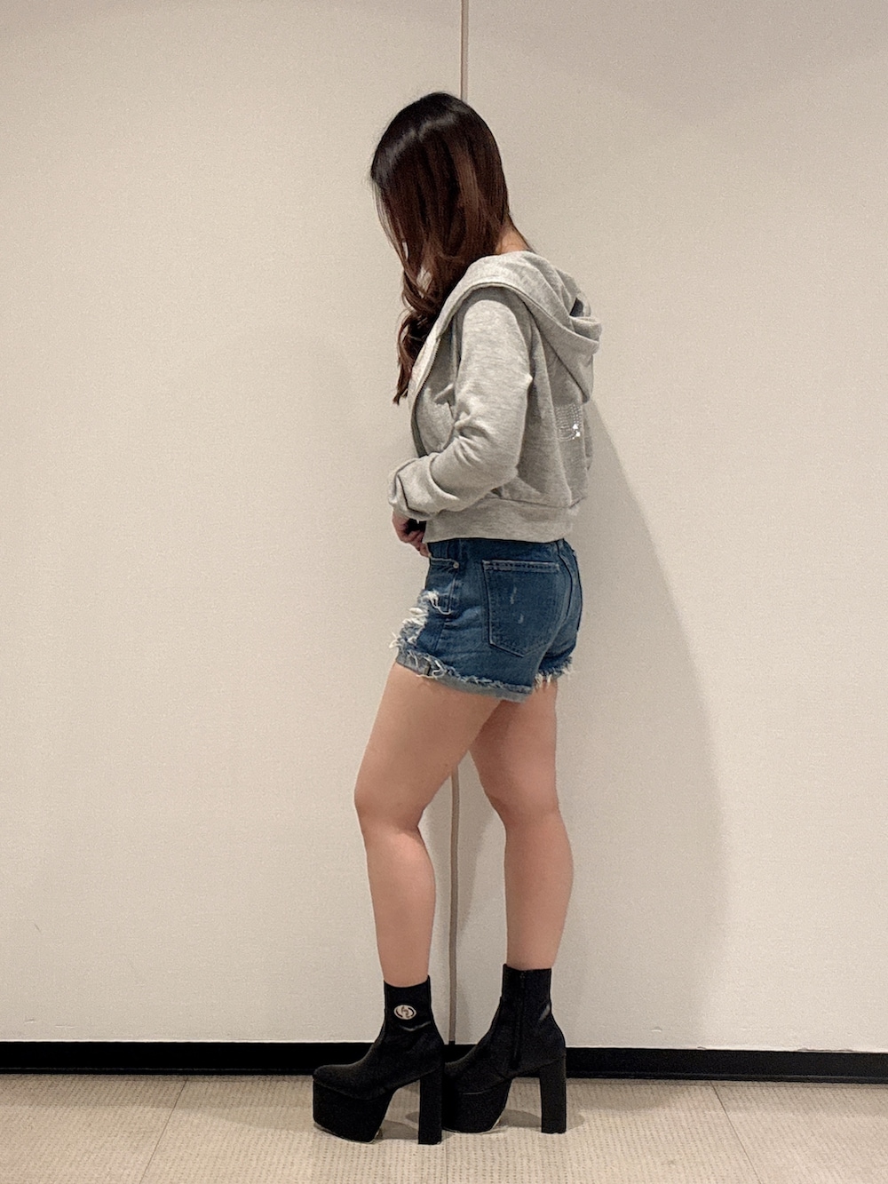 ブラック系のキャミソール、グレー系のパーカー、ブルー系のデニムパンツを着用したレディースの春コーディネートの2枚目の写真