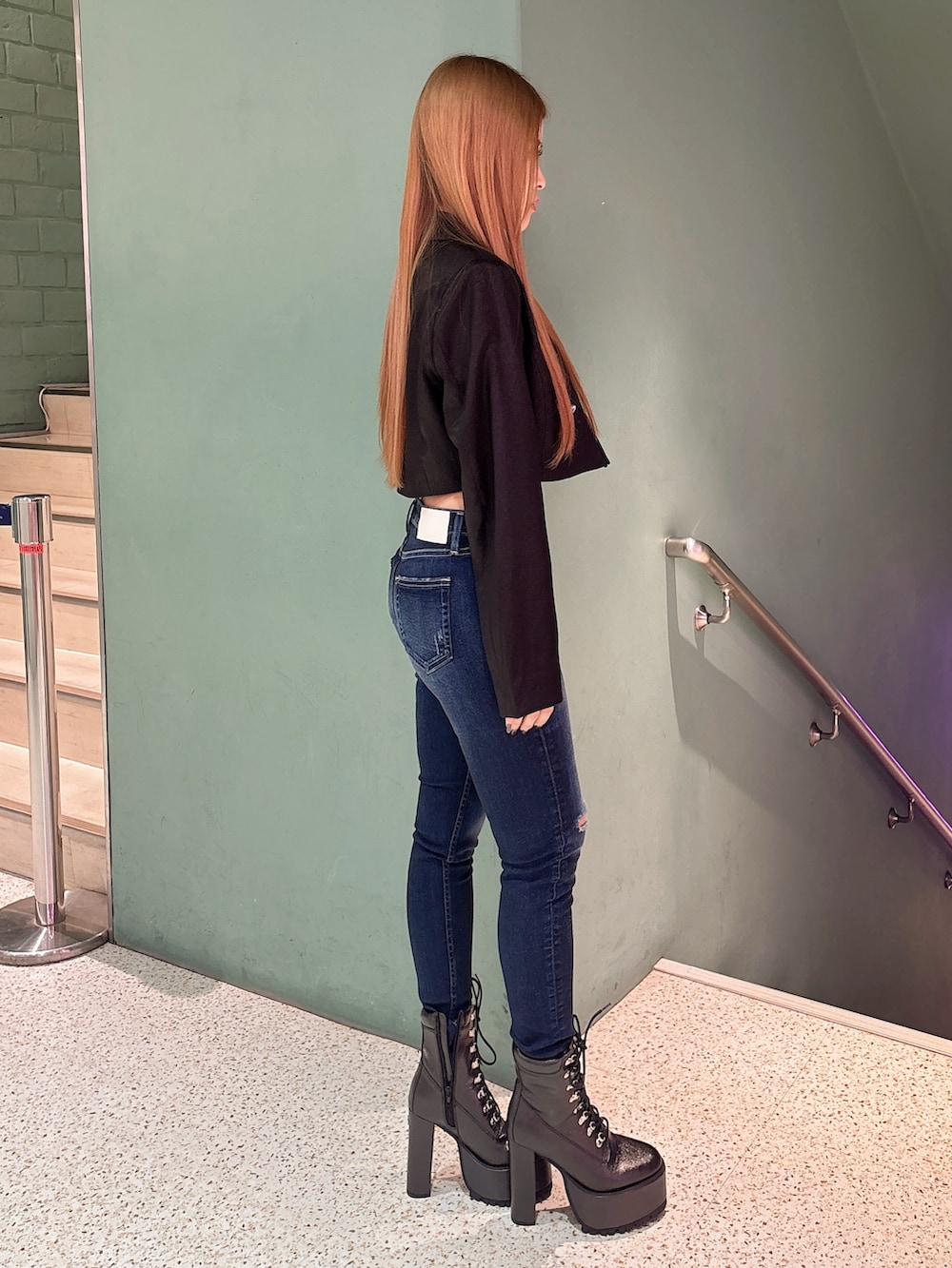 ホワイト系のキャミソール、ブラック系のテーラードジャケット、ブルー系のデニムパンツを着用したレディースの春コーディネートの2枚目の写真