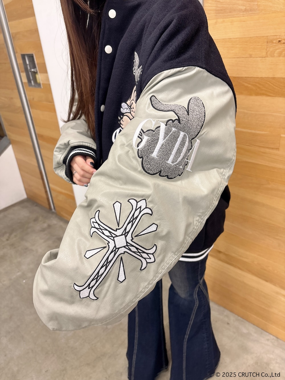 ブラック系のスタジャン、ホワイト系のニット/セーター、ブルー系のデニムパンツを着用したレディースの秋コーディネートの7枚目の写真