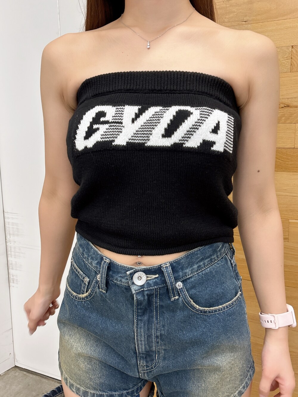 ブラック系のニット/セーター、ブルー系のデニムパンツ、ブラック系のサンダルを着用したレディースの夏コーディネートの5枚目の写真