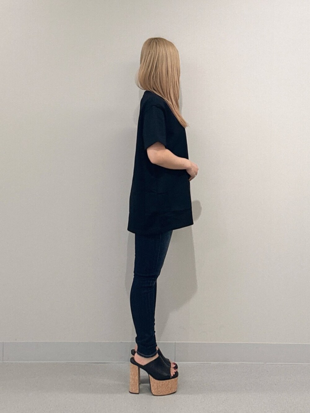 ブルー系のデニムパンツ、ブラック系のサンダル、ブラック系のTシャツ/カットソーを着用したレディースの夏コーディネートの2枚目の写真