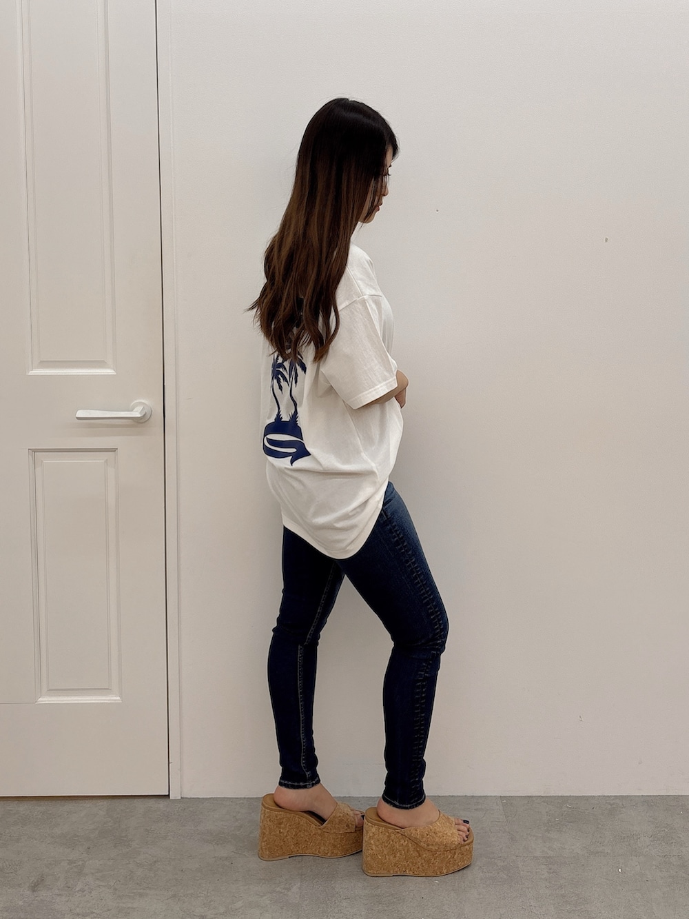 ホワイト系のTシャツ/カットソー、ブルー系のデニムパンツ、ベージュ系のサンダルを着用したレディースの夏コーディネートの2枚目の写真