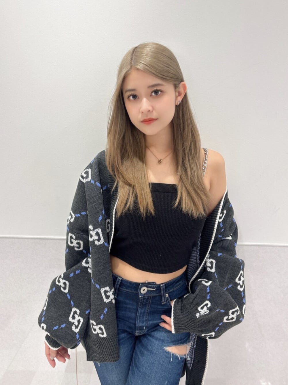 ブルー系のデニムパンツ、ブラック系のキャミソール、ブラック系のブーツを着用したレディースの夏コーディネートの4枚目の写真