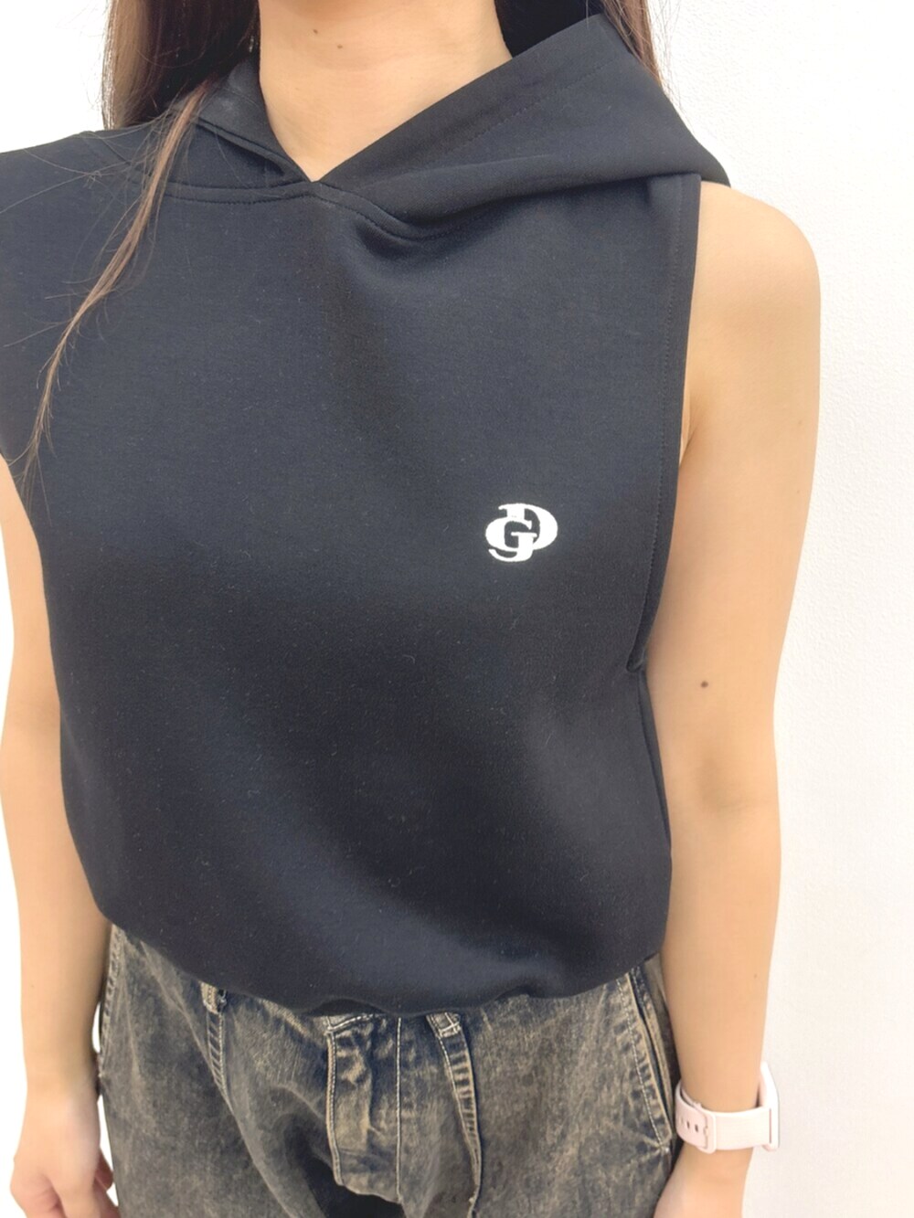 ブラック系のパーカー、ブルー系のデニムパンツ、ブラック系のサンダルを着用したレディースの夏コーディネートの6枚目の写真