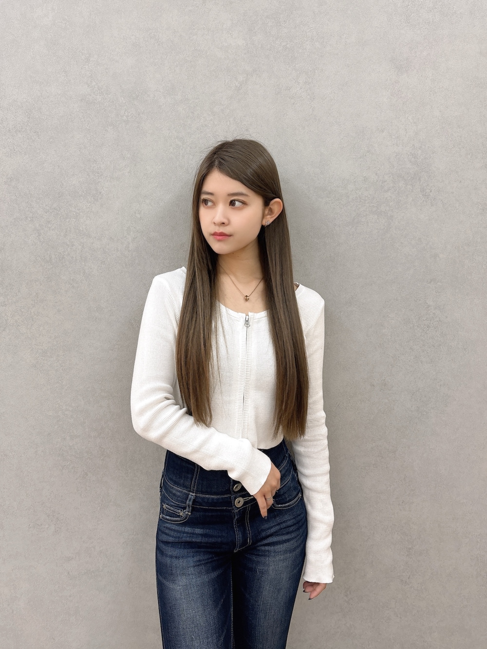 ホワイト系のニット/セーター、ブルー系のデニムパンツ、ブラック系のパンプスを着用したレディースの春コーディネートの4枚目の写真