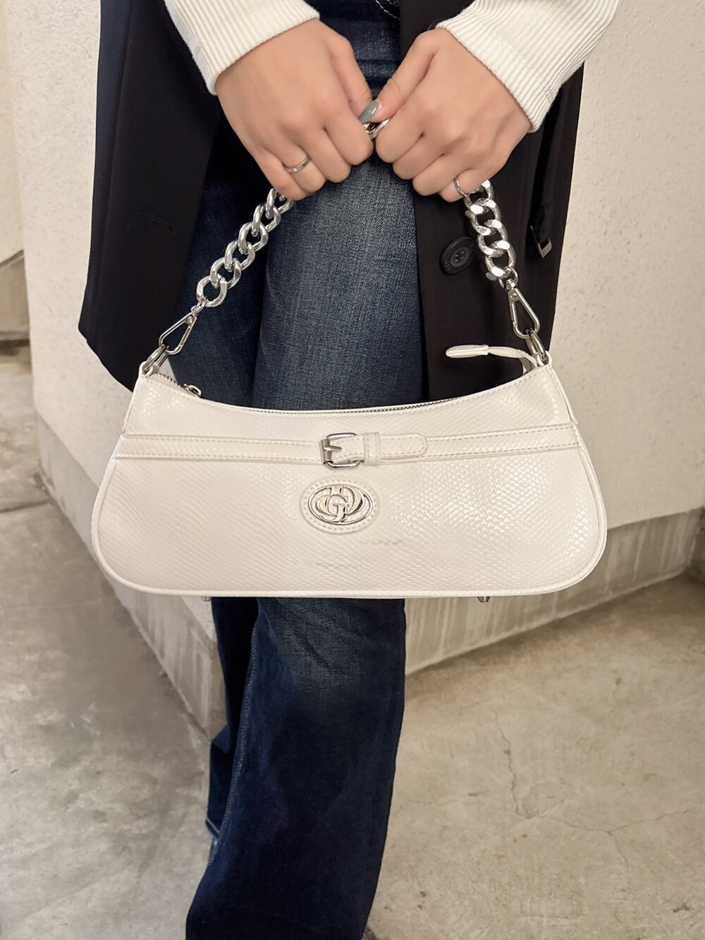 ホワイト系のTシャツ/カットソー、ブラック系のベスト、ブルー系のデニムパンツを着用したレディースの春コーディネートの6枚目の写真