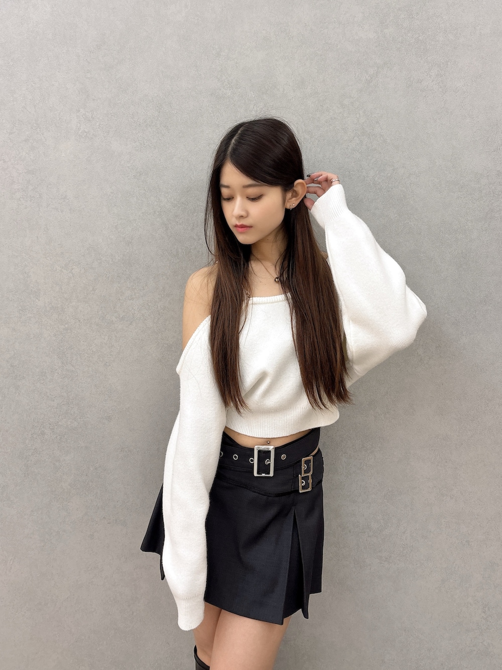 ホワイト系のニット/セーター、ブラック系のスカート、ブラック系のブーツを着用したレディースの秋コーディネートの5枚目の写真