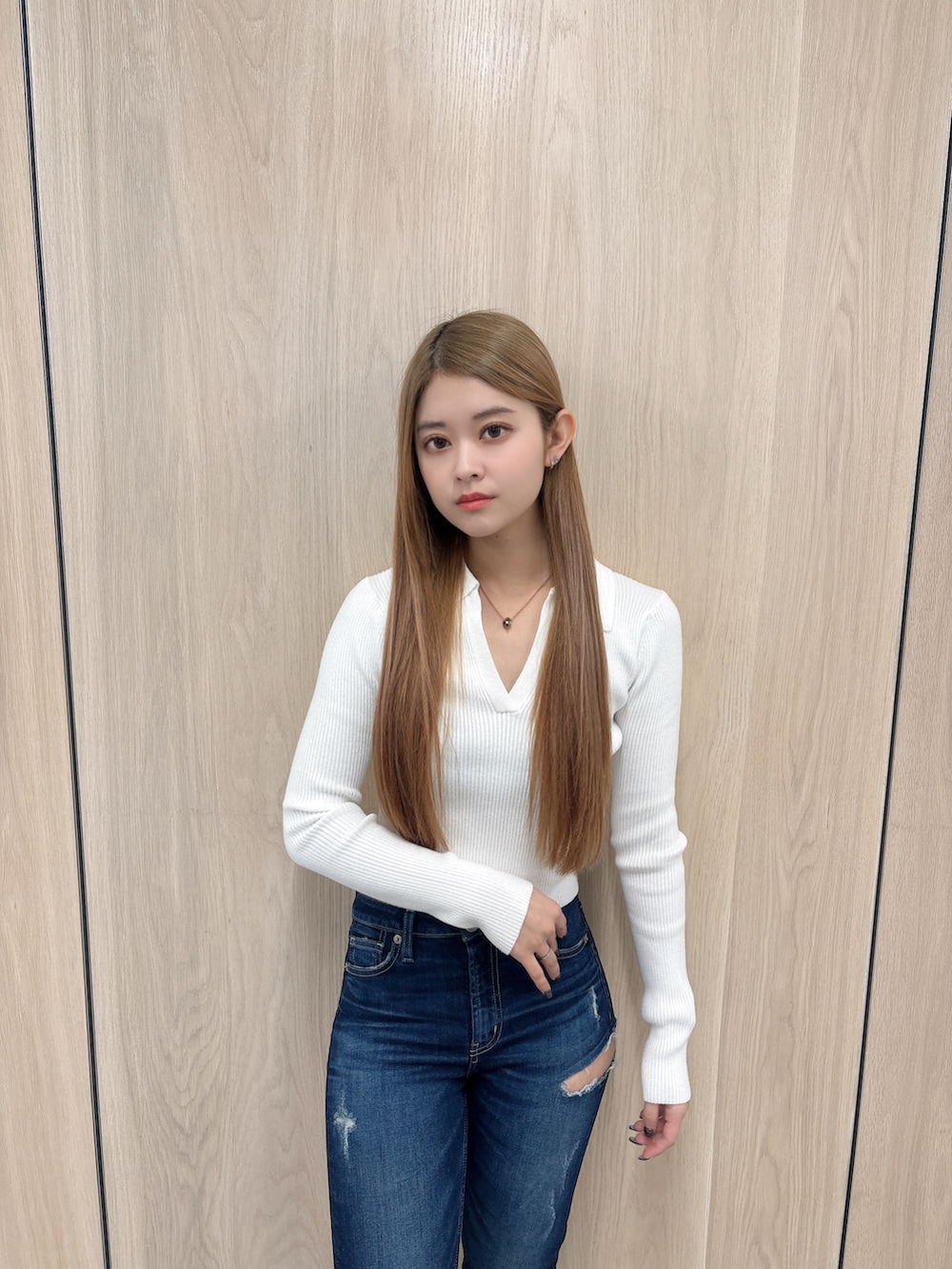 ホワイト系のニット/セーター、ブルー系のデニムパンツ、ブラック系のブーツを着用したレディースの春コーディネートの4枚目の写真