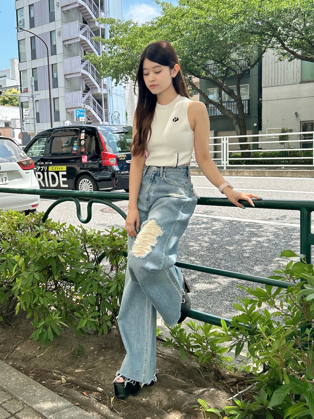 ホワイト系のニット/セーター、ブルー系のデニムパンツ、ブラック系のサンダルを着用したレディースの夏コーディネートの5枚目の写真