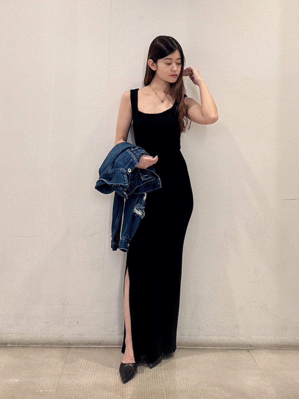 ブラック系のワンピース、ブルー系のデニムジャケット、ブラック系のパンプスを着用したレディースの春コーディネートの2枚目の写真