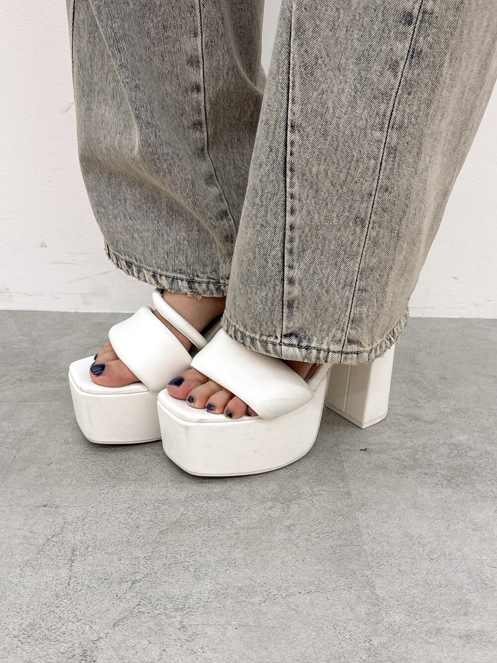 ブラック系のニット/セーター、ブルー系のデニムパンツ、ブラック系のバックパック/リュックを着用したレディースの夏コーディネートの9枚目の写真