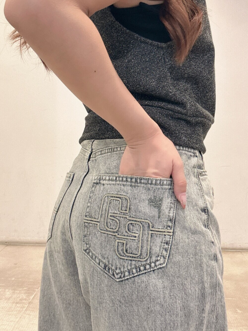 ブルー系のデニムパンツ、ブラック系のTシャツ/カットソー、ブラック系のスニーカーを着用したレディースの夏コーディネートの7枚目の写真