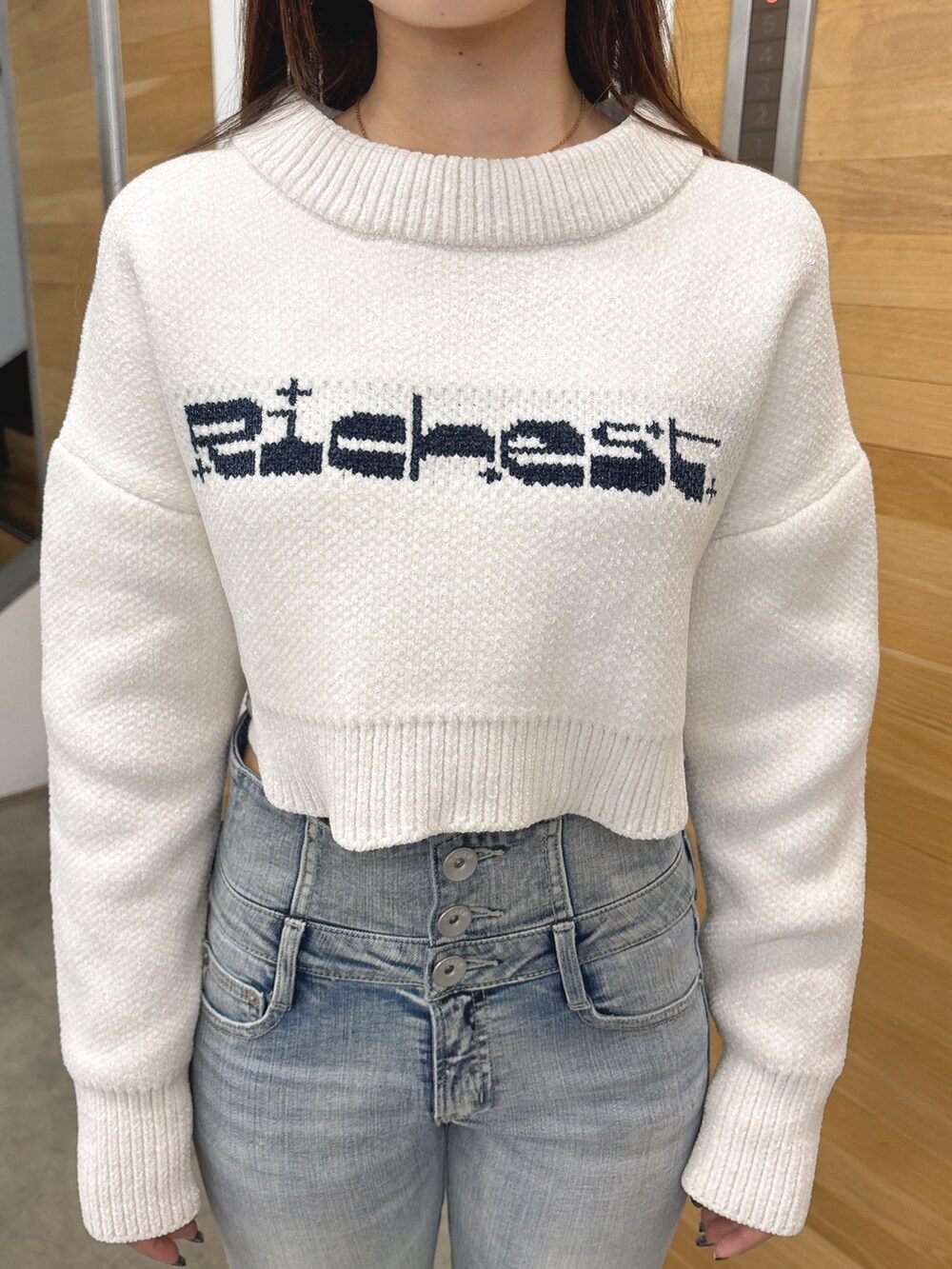 ホワイト系のニット/セーター、ブルー系のデニムパンツ、ブラック系のブーツを着用したレディースの秋コーディネートの6枚目の写真