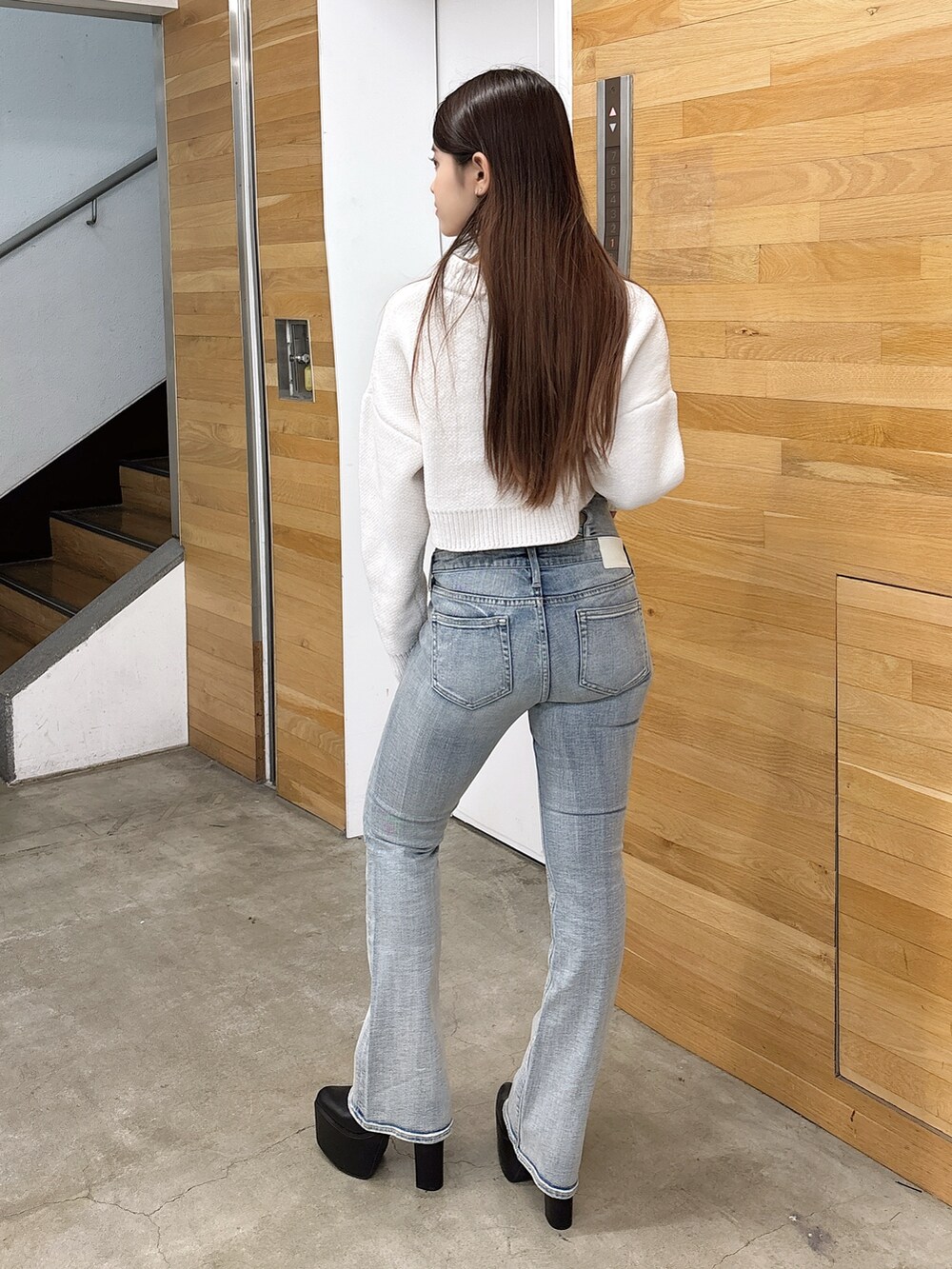 ホワイト系のニット/セーター、ブルー系のデニムパンツ、ブラック系のブーツを着用したレディースの秋コーディネートの3枚目の写真