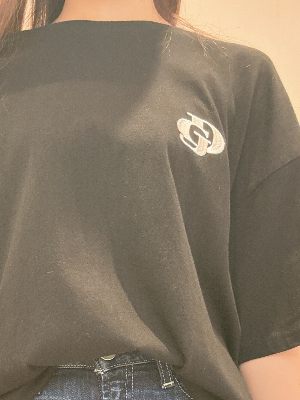 ブラック系のTシャツ/カットソー、ブルー系のデニムパンツ、ブラック系のパンプスを着用したレディースの春コーディネートの5枚目の写真