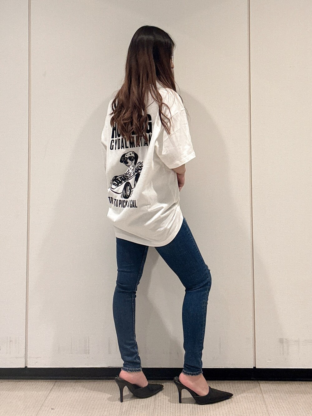 ホワイト系のTシャツ/カットソー、ブルー系のデニムパンツ、ブラック系のパンプスを着用したレディースの春コーディネートの2枚目の写真