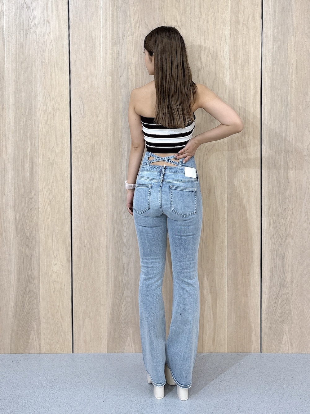 ブラック系のニット/セーター、ブルー系のデニムパンツ、ホワイト系のサンダルを着用したレディースの夏コーディネートの3枚目の写真