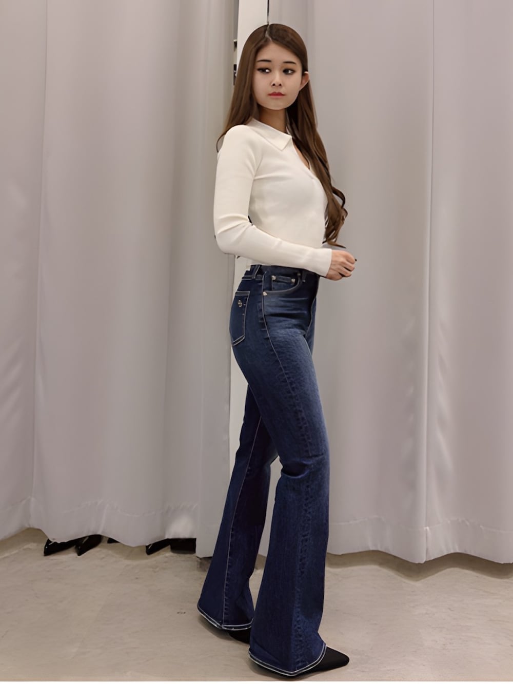 ホワイト系のニット/セーター、ブルー系のデニムパンツ、ブラック系のパンプスを着用したレディースの春コーディネートの2枚目の写真