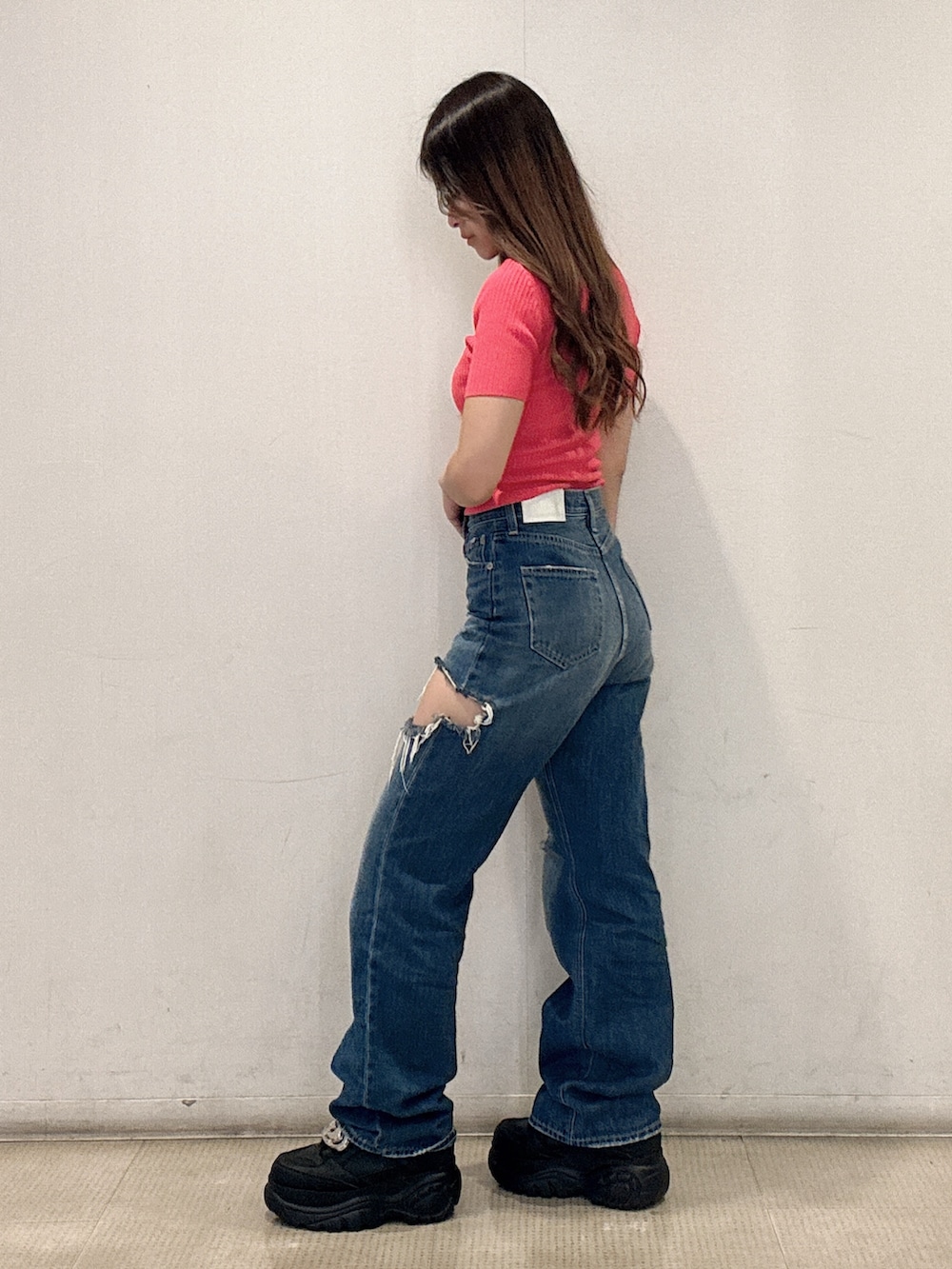 ピンク系のニット/セーター、ブルー系のデニムパンツ、ブラック系のスニーカーを着用したレディースの春コーディネートの2枚目の写真