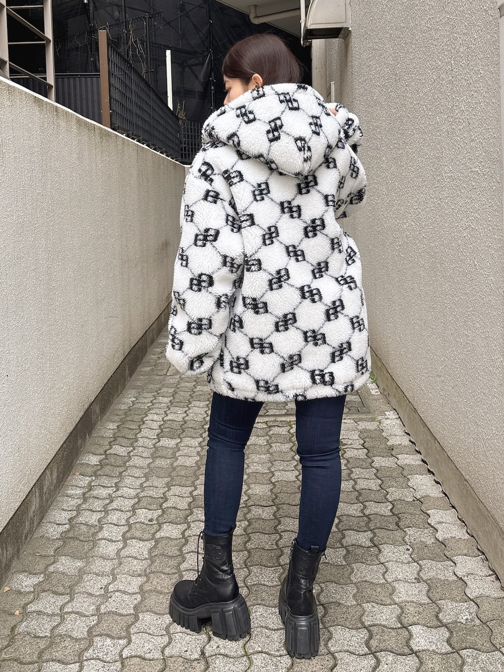 ブルー系のニット/セーター、ブルー系のデニムパンツ、ホワイト系のブルゾンを着用したレディースの秋コーディネートの3枚目の写真