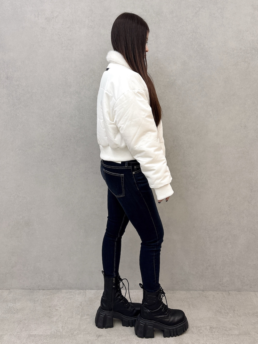 ブラック系のブーツ、ブルー系のデニムパンツ、ブラック系のTシャツ/カットソーを着用したレディースの秋コーディネートの2枚目の写真