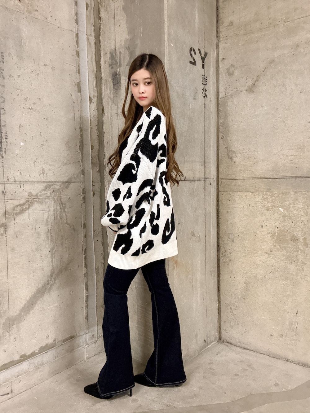 ブラック系のキャミソール、ホワイト系のカーディガン/ボレロ、ブルー系のデニムパンツを着用したレディースの春コーディネートの2枚目の写真