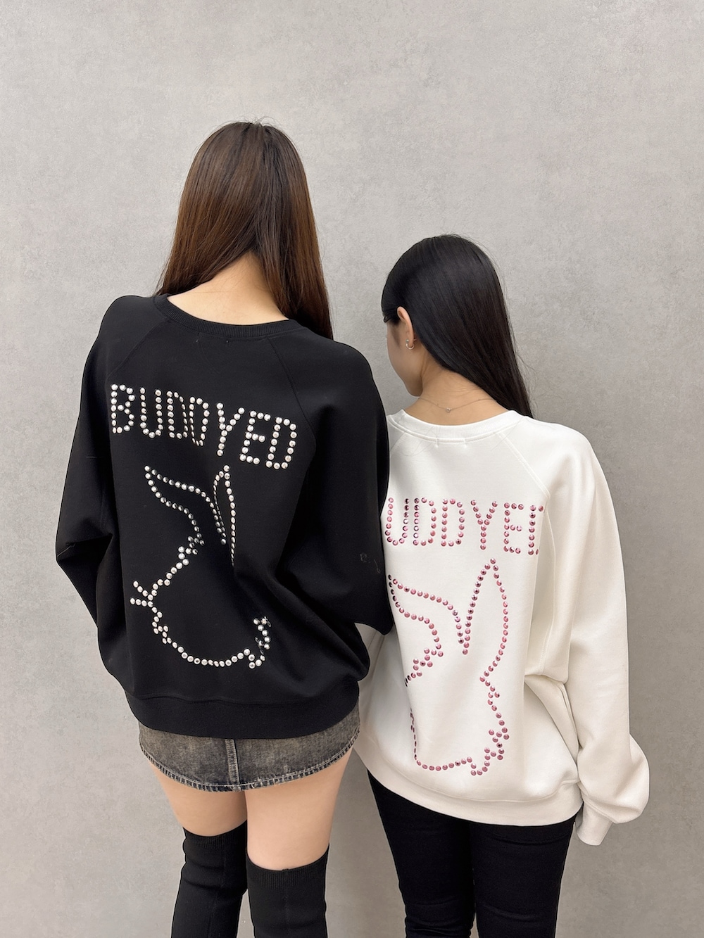 ホワイト系のスウェット、ブラック系のデニムパンツ、ブラック系のブーツを着用したレディースの冬コーディネートの6枚目の写真