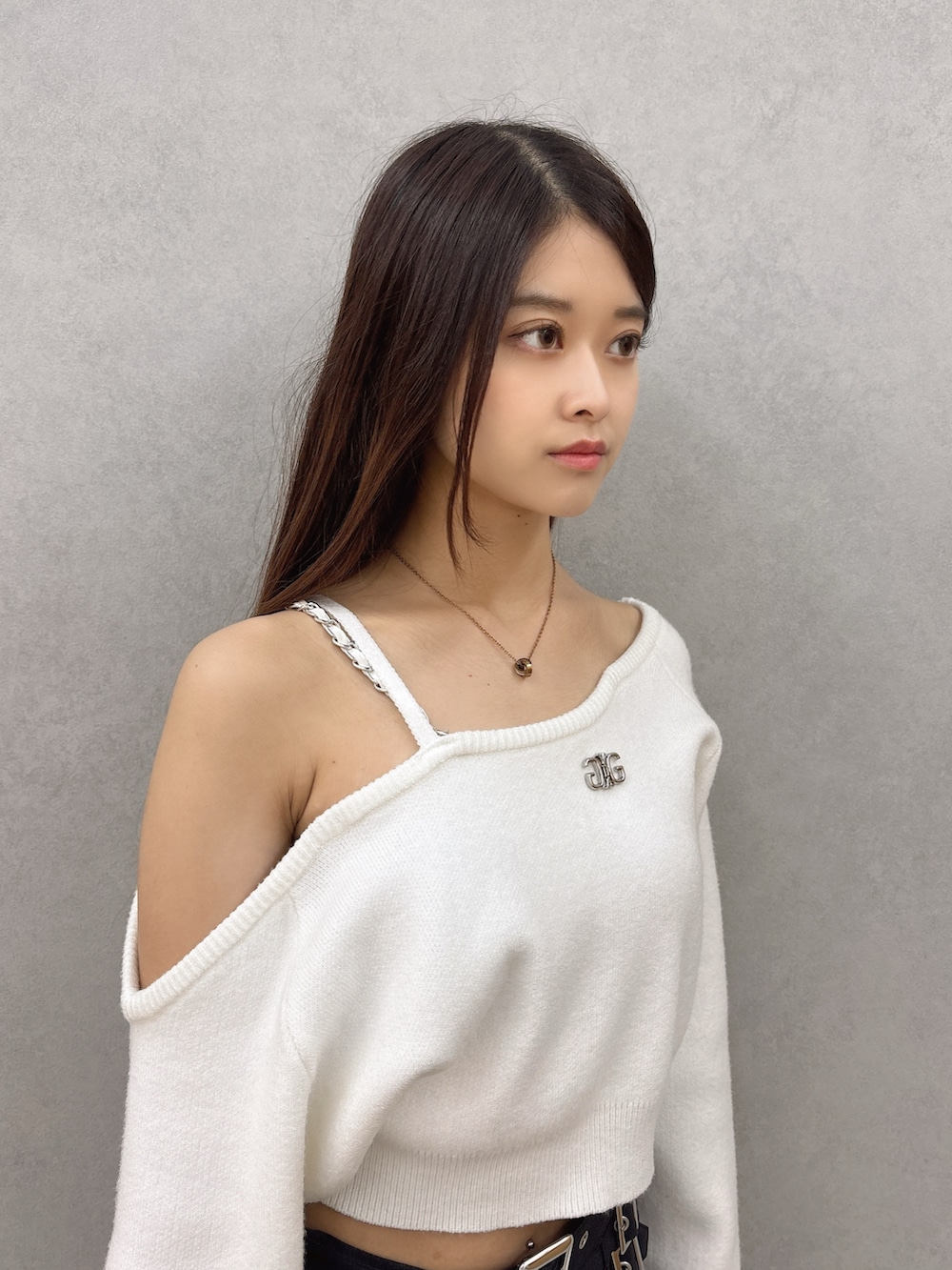 ホワイト系のニット/セーター、ブラック系のスカート、ブラック系のブーツを着用したレディースの秋コーディネートの7枚目の写真