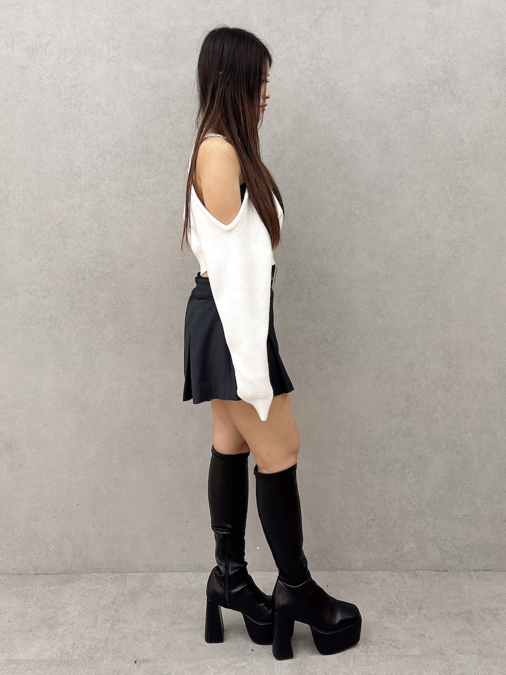 ホワイト系のニット/セーター、ブラック系のスカート、ブラック系のブーツを着用したレディースの秋コーディネートの3枚目の写真