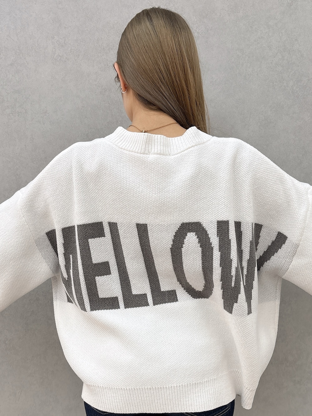 ブラック系のキャミソール、ホワイト系のカーディガン/ボレロ、ブルー系のデニムパンツを着用したレディースの春コーディネートの5枚目の写真