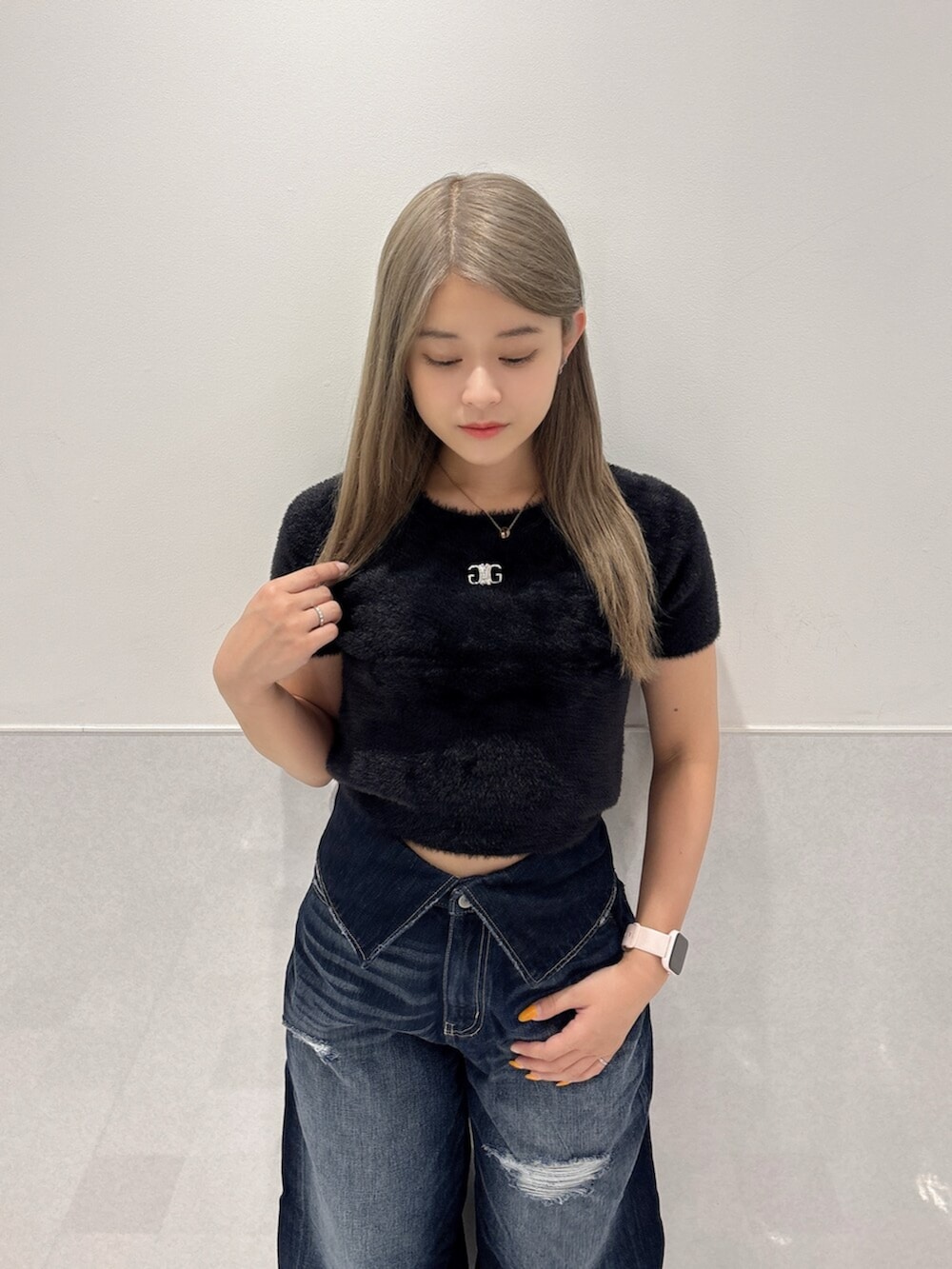 ブラック系のニット/セーター、ブルー系のデニムパンツ、ブラック系のスニーカーを着用したレディースの夏コーディネートの4枚目の写真